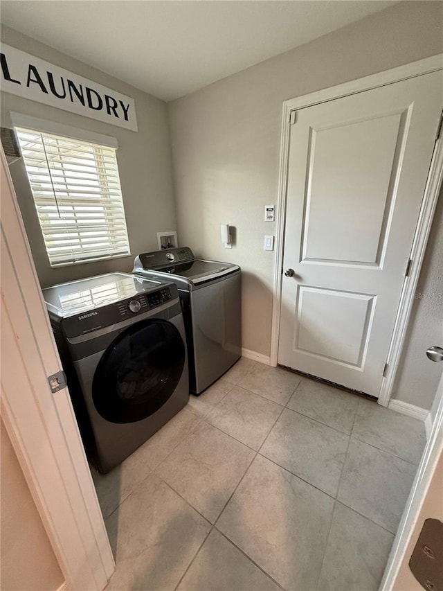 clothes washing area featuring separate washer and dryer and light tile patterned flooring