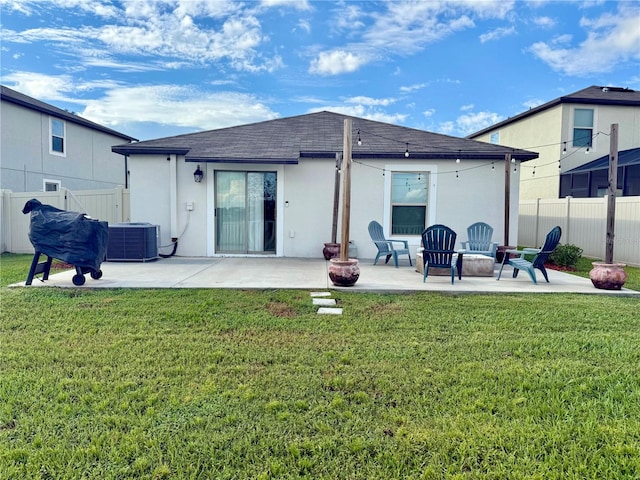 rear view of property with a yard, central AC unit, and a patio area