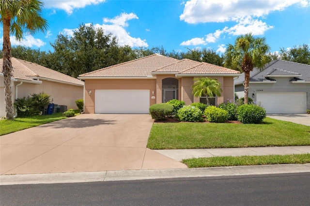 mediterranean / spanish-style house with a garage and a front lawn