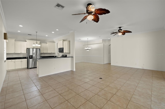 interior space with ceiling fan with notable chandelier, decorative light fixtures, appliances with stainless steel finishes, and white cabinetry