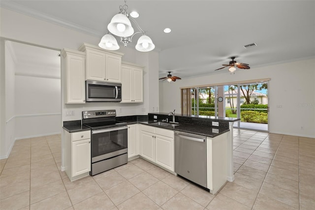 kitchen featuring white cabinets, sink, kitchen peninsula, crown molding, and appliances with stainless steel finishes