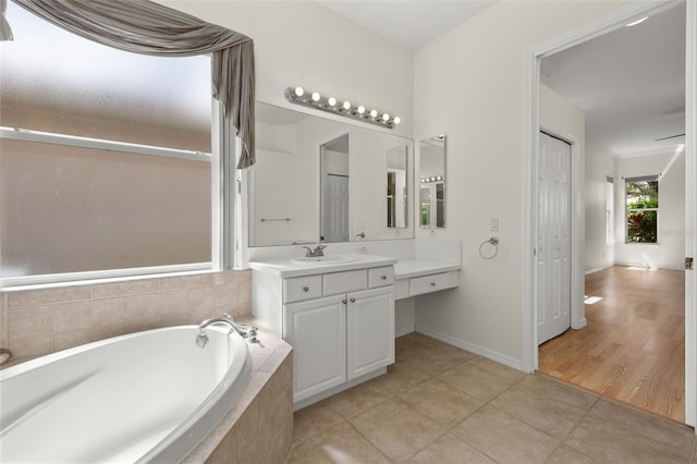 bathroom featuring tiled tub, tile patterned floors, and vanity