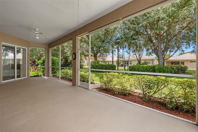 unfurnished sunroom featuring ceiling fan