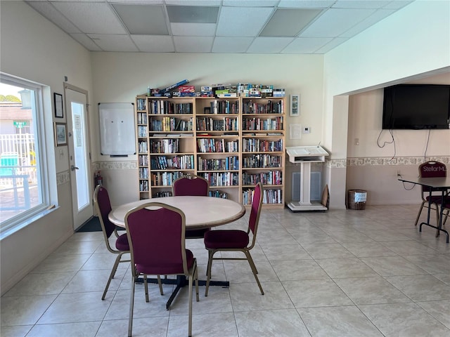 tiled dining area with a paneled ceiling