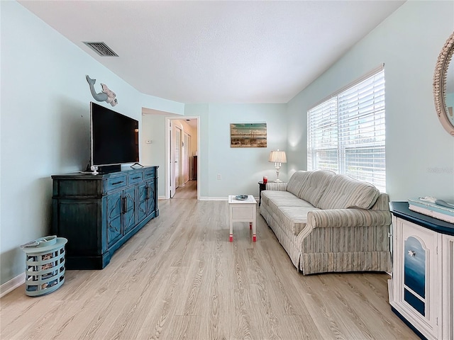 living room with light hardwood / wood-style flooring and a textured ceiling