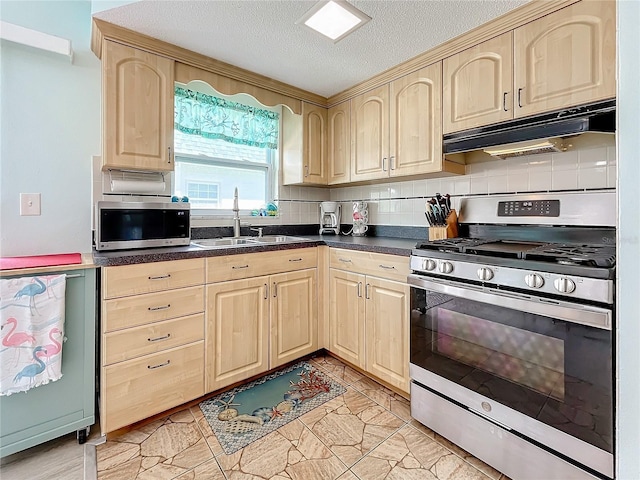 kitchen with appliances with stainless steel finishes, a textured ceiling, light brown cabinets, and sink