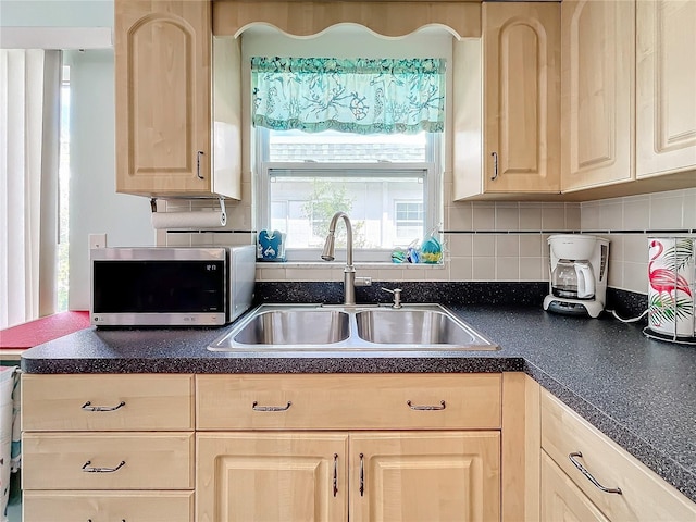 kitchen featuring light brown cabinets, tasteful backsplash, and sink