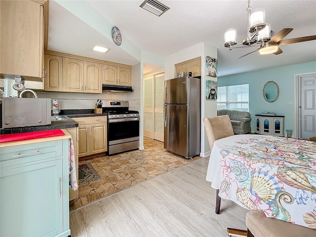 kitchen with ceiling fan, light brown cabinets, backsplash, light hardwood / wood-style floors, and appliances with stainless steel finishes