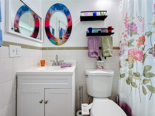 bathroom with vanity, toilet, curtained shower, and tile walls