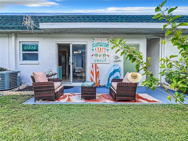 entrance to property featuring a lawn and central air condition unit