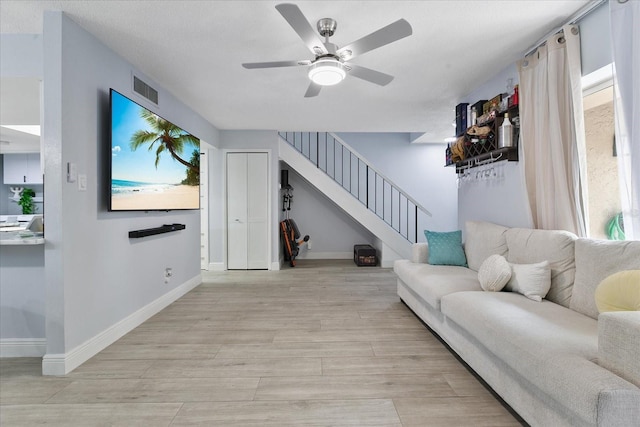 living room with ceiling fan and light wood-type flooring