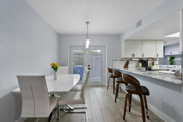 dining area featuring french doors, a textured ceiling, and hardwood / wood-style floors