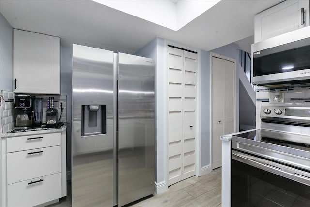 kitchen with stainless steel appliances and white cabinets