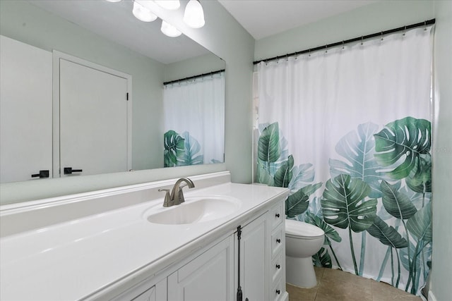 bathroom featuring tile patterned flooring, vanity, and toilet