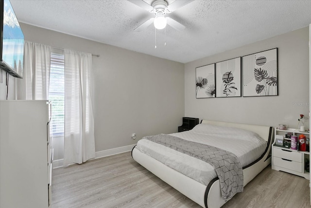 bedroom featuring light wood-type flooring, ceiling fan, and a textured ceiling