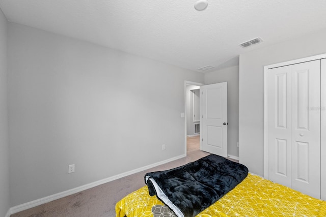 carpeted bedroom featuring a closet and a textured ceiling