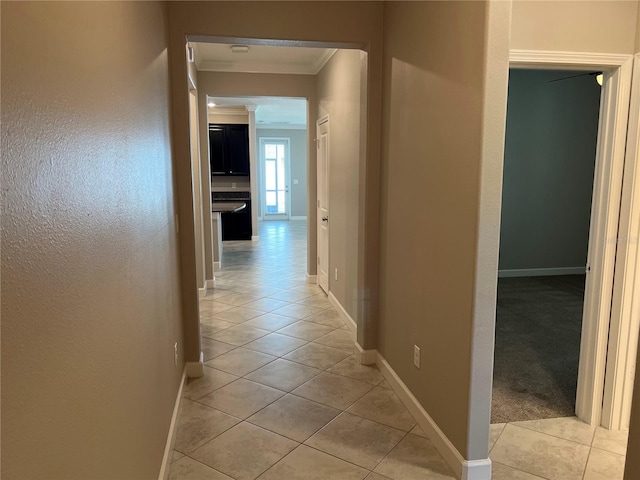 hall featuring crown molding and light tile patterned floors