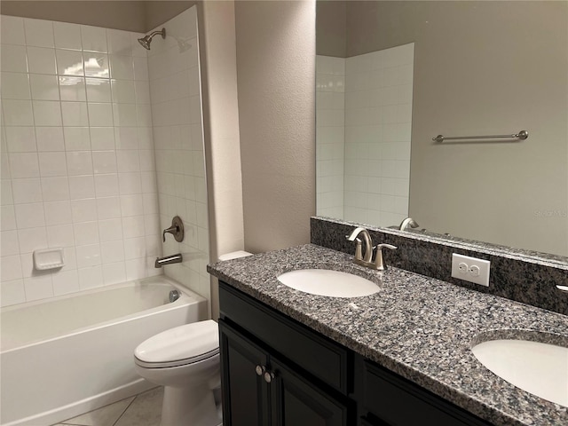 full bathroom featuring tile patterned flooring, tiled shower / bath, vanity, and toilet