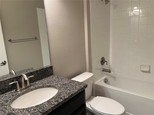 full bathroom with tiled shower / bath, vanity, and toilet