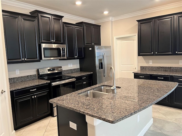 kitchen featuring ornamental molding, sink, a kitchen island with sink, stainless steel appliances, and dark stone countertops