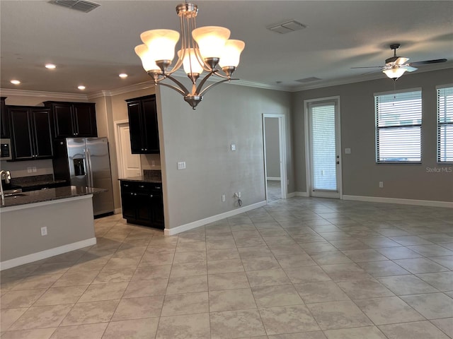 kitchen featuring appliances with stainless steel finishes, hanging light fixtures, dark stone countertops, and crown molding