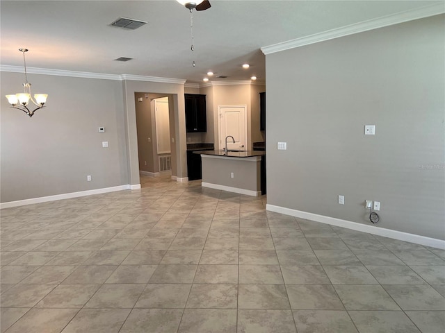 unfurnished living room featuring an inviting chandelier, sink, and crown molding