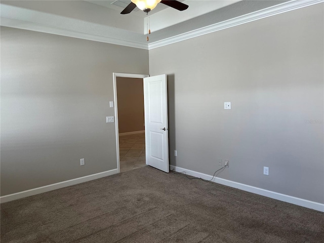 empty room with dark carpet, ceiling fan, and ornamental molding