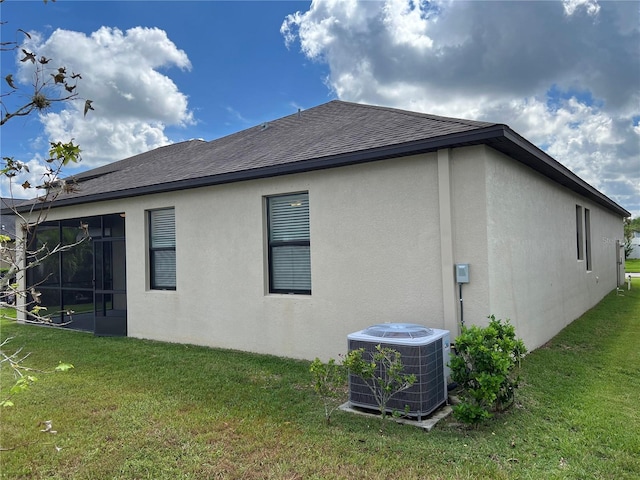 rear view of house with a sunroom, cooling unit, and a yard