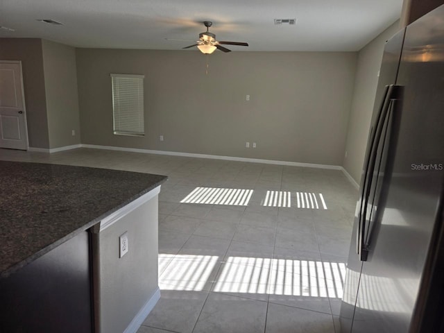 unfurnished living room featuring ceiling fan and light tile patterned floors