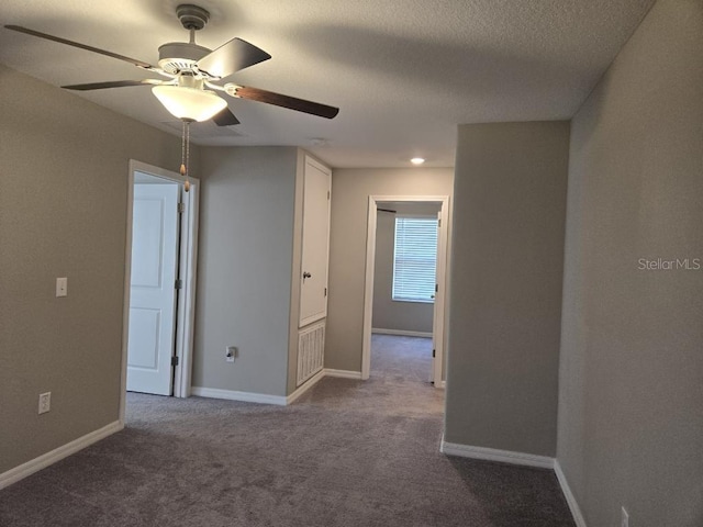 carpeted spare room with ceiling fan and a textured ceiling