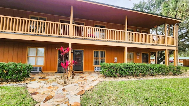 rear view of house featuring a yard, a balcony, and a patio area