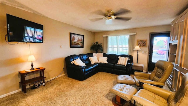 living room featuring light carpet, ceiling fan, and a textured ceiling