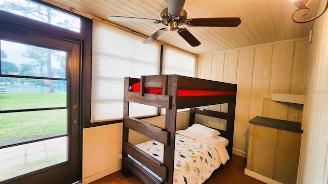 tiled bedroom with wood ceiling, wood walls, and ceiling fan