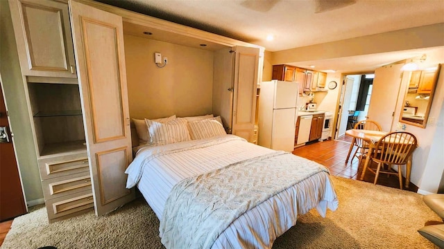 bedroom with light tile patterned floors, ceiling fan, and white fridge