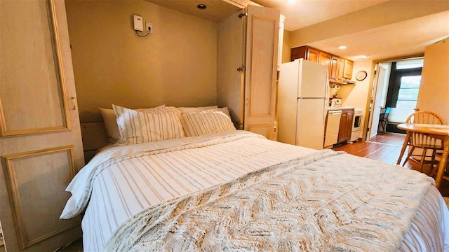 bedroom featuring light tile patterned floors and white fridge