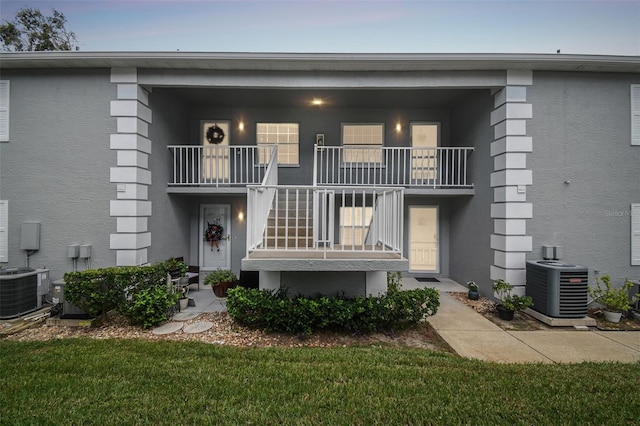 exterior space featuring central air condition unit, a yard, and a balcony