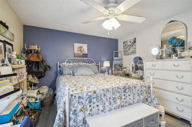 bedroom featuring a textured ceiling, wood-type flooring, and ceiling fan