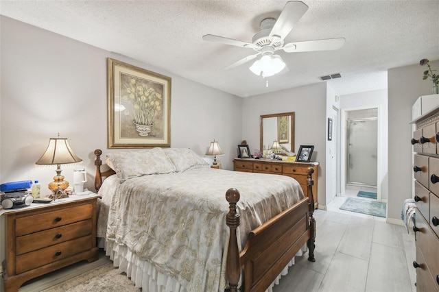 bedroom with light tile patterned floors, ceiling fan, a textured ceiling, a closet, and ensuite bath