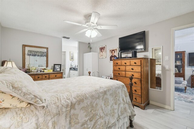 bedroom with light hardwood / wood-style floors, a textured ceiling, and ceiling fan