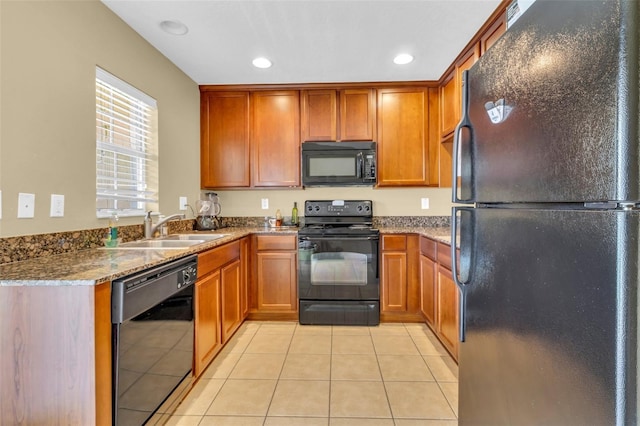 kitchen featuring light tile patterned floors, sink, stone countertops, and black appliances