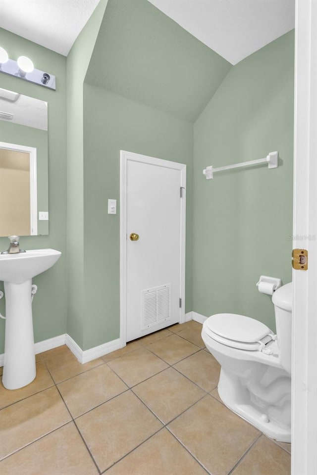 bathroom featuring vaulted ceiling, tile patterned floors, and toilet