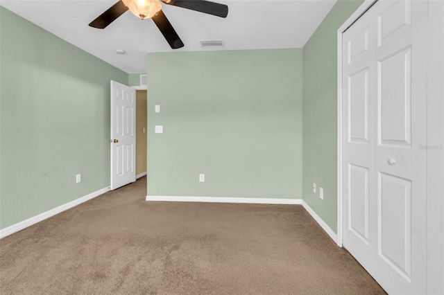 unfurnished bedroom with a closet, carpet, and ceiling fan