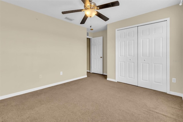 unfurnished bedroom with ceiling fan, a closet, and carpet flooring