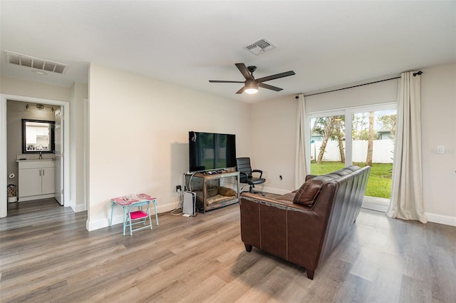 living room with light wood-type flooring and ceiling fan