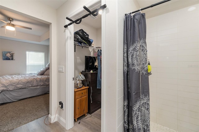 bathroom with ceiling fan, hardwood / wood-style flooring, and a shower with shower curtain