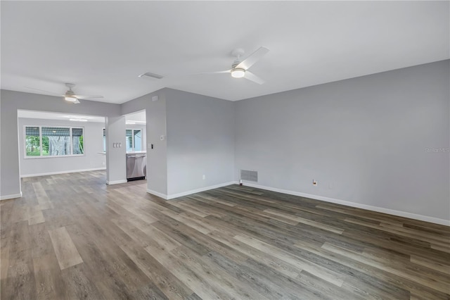 unfurnished living room with dark wood-type flooring and ceiling fan