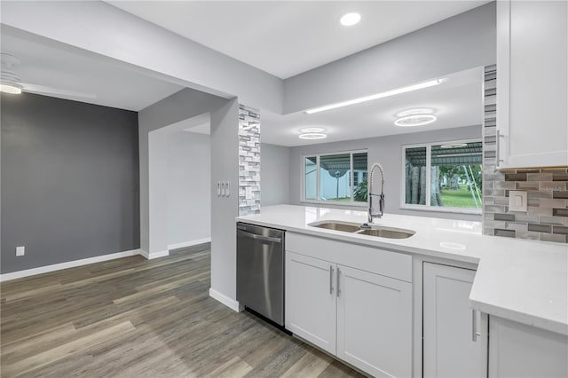 kitchen featuring sink, backsplash, wood-type flooring, white cabinets, and stainless steel dishwasher