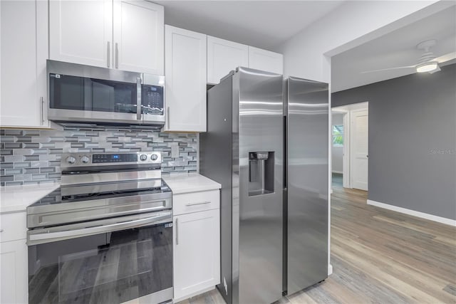 kitchen featuring appliances with stainless steel finishes, white cabinets, and decorative backsplash