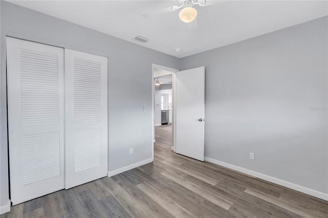 unfurnished bedroom featuring ceiling fan, a closet, and light hardwood / wood-style flooring