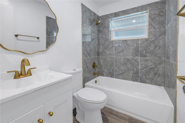 full bathroom featuring tiled shower / bath combo, vanity, hardwood / wood-style floors, and toilet